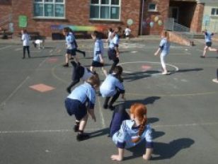 P3/4 children practicing Fundamental Movement Skills in P.E.